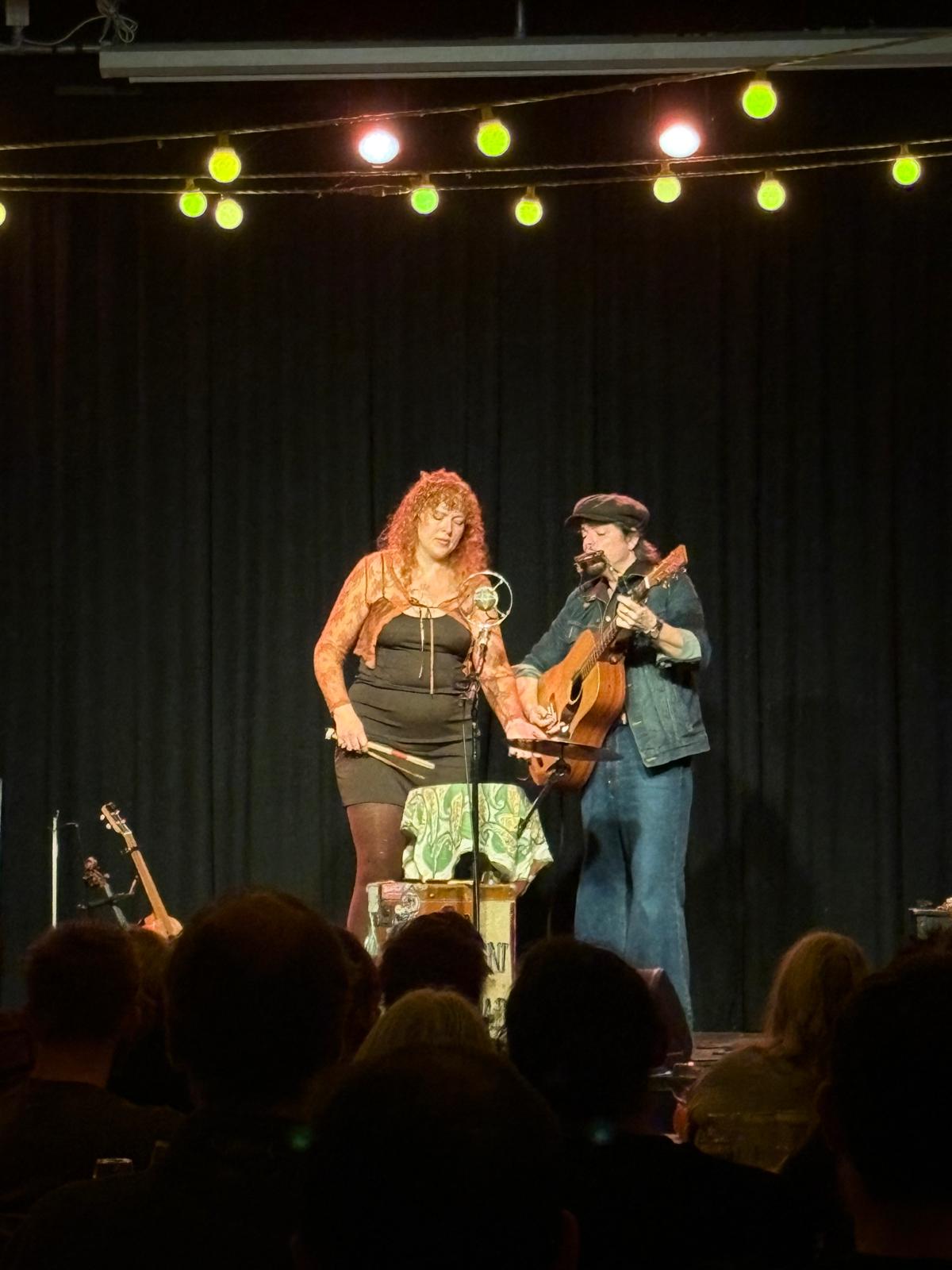 Alicia Best and Robert Jackson performing with guitar, harmonica and suitcase percussion